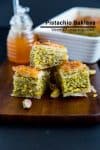 Three squares of pistachio baklava on a table.