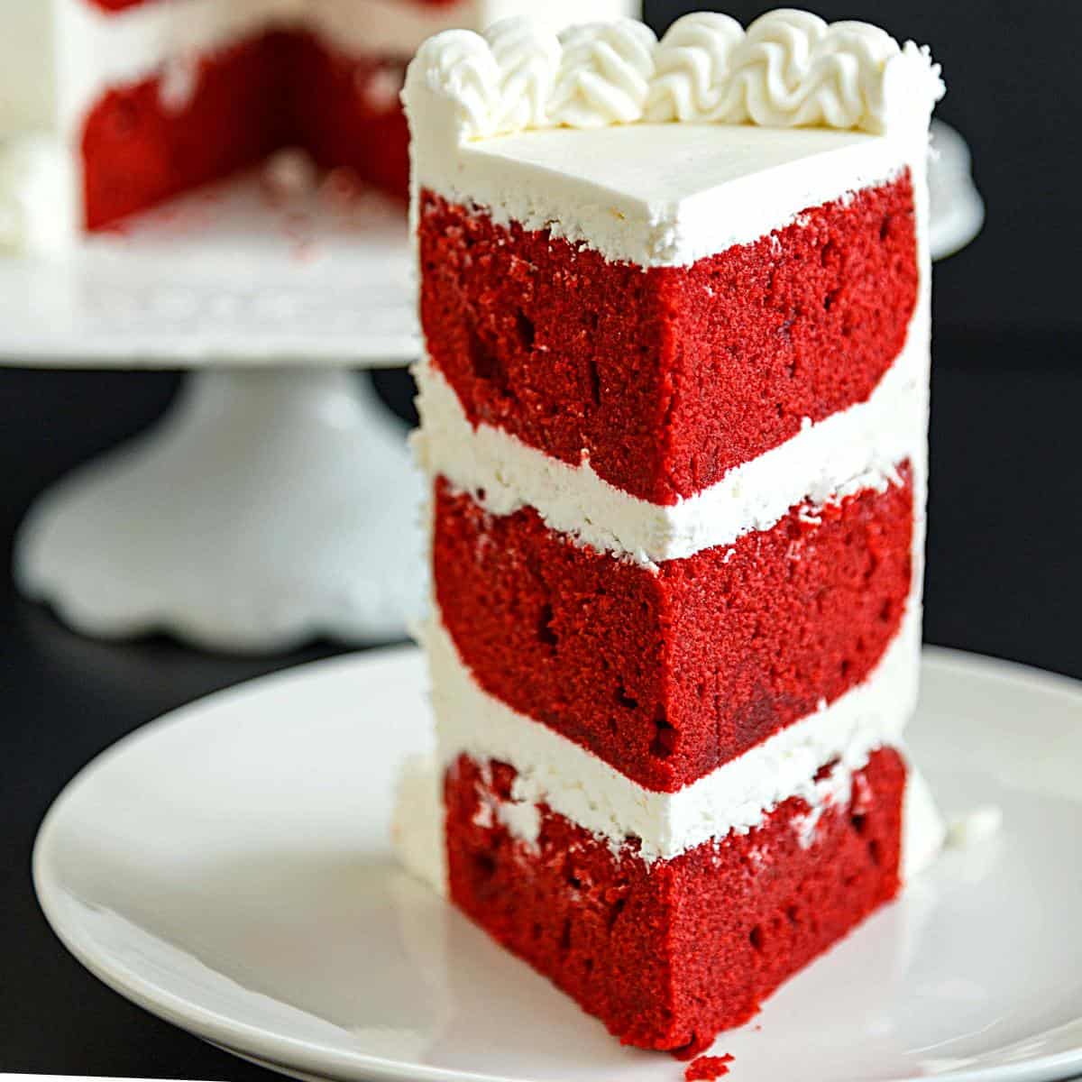 A slice of red velvet layer cake.