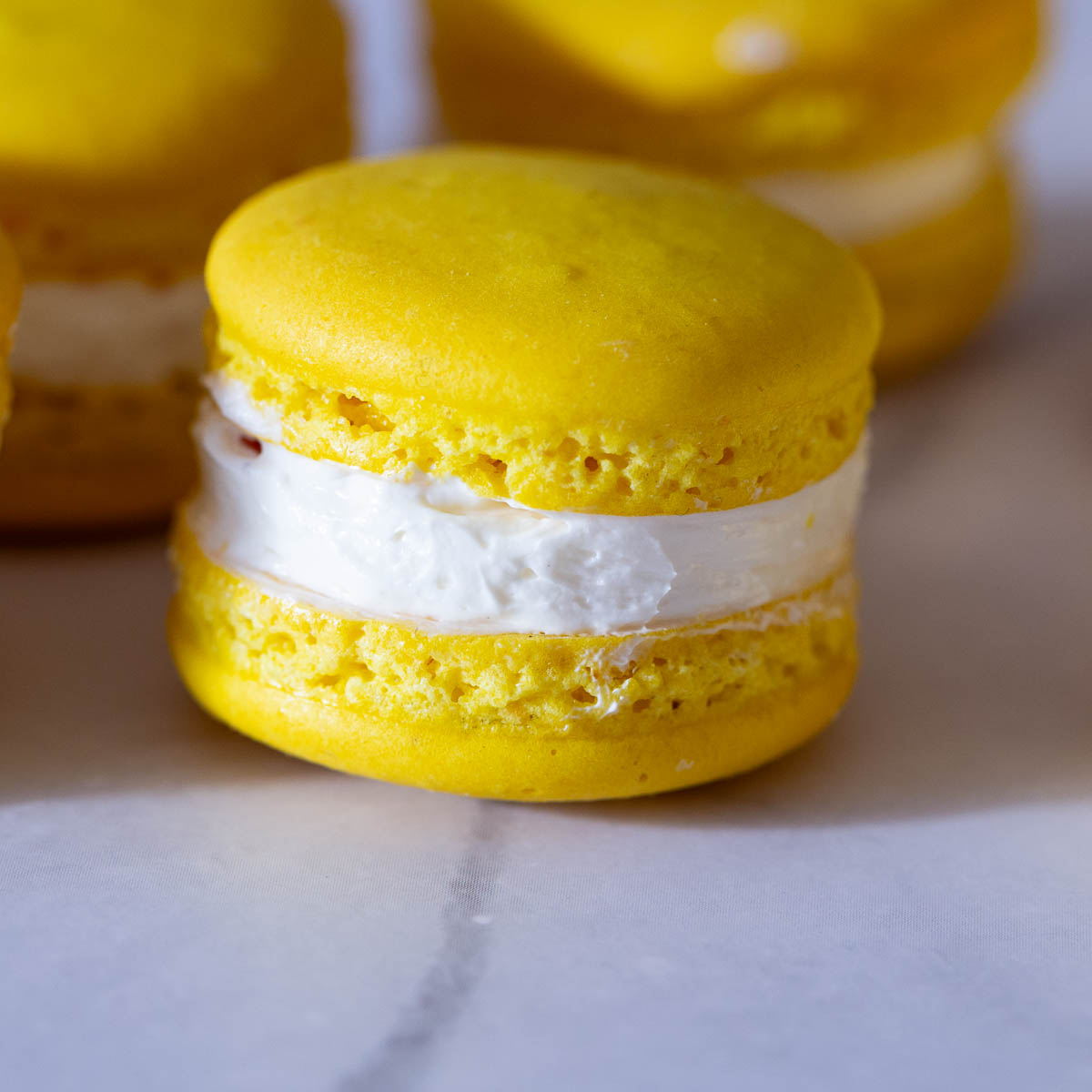 Stack of yellow macarons on the table.