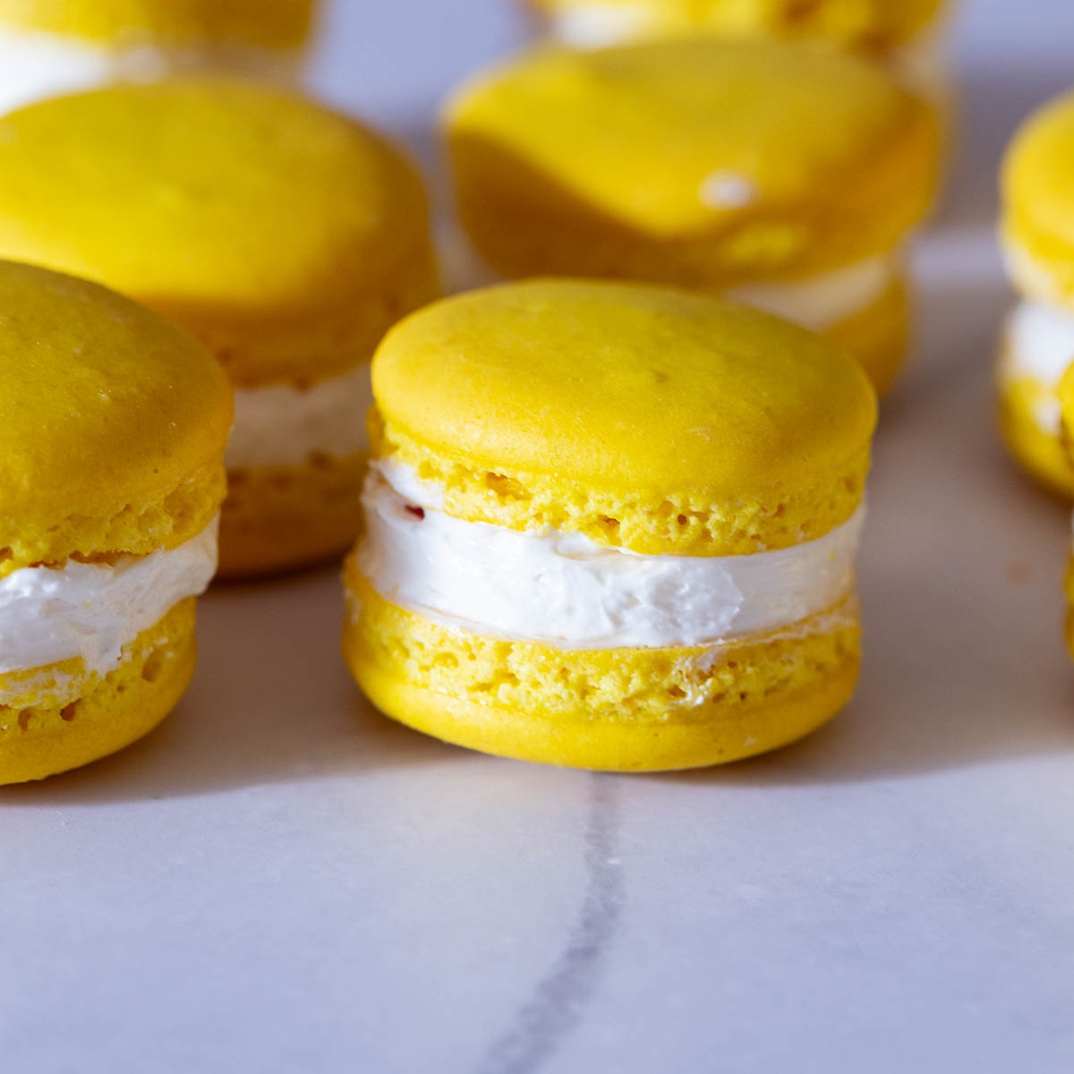 Stack of yellow macarons on the table.