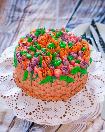 A cake decorated with buttercream to look like a basket of flowers.