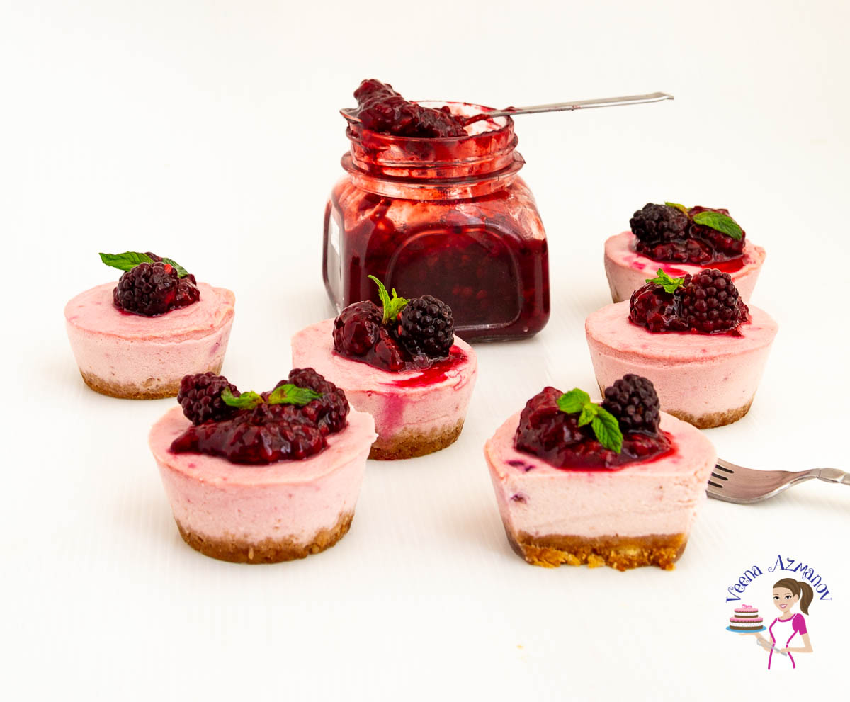 Mini blackberry cheesecakes on a table.