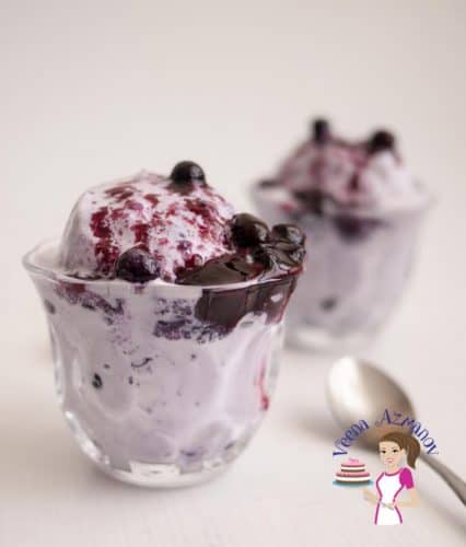 Blueberry ice cream in a small glass bowl.
