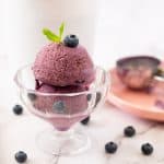 A glass bowl with two scoops of ice cream.