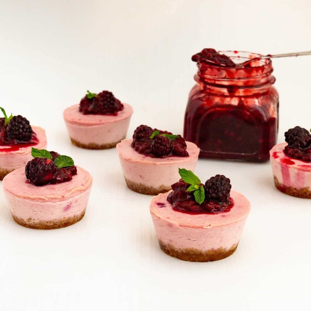 Mini cheesecakes with a mason jar of blackberry filling.
