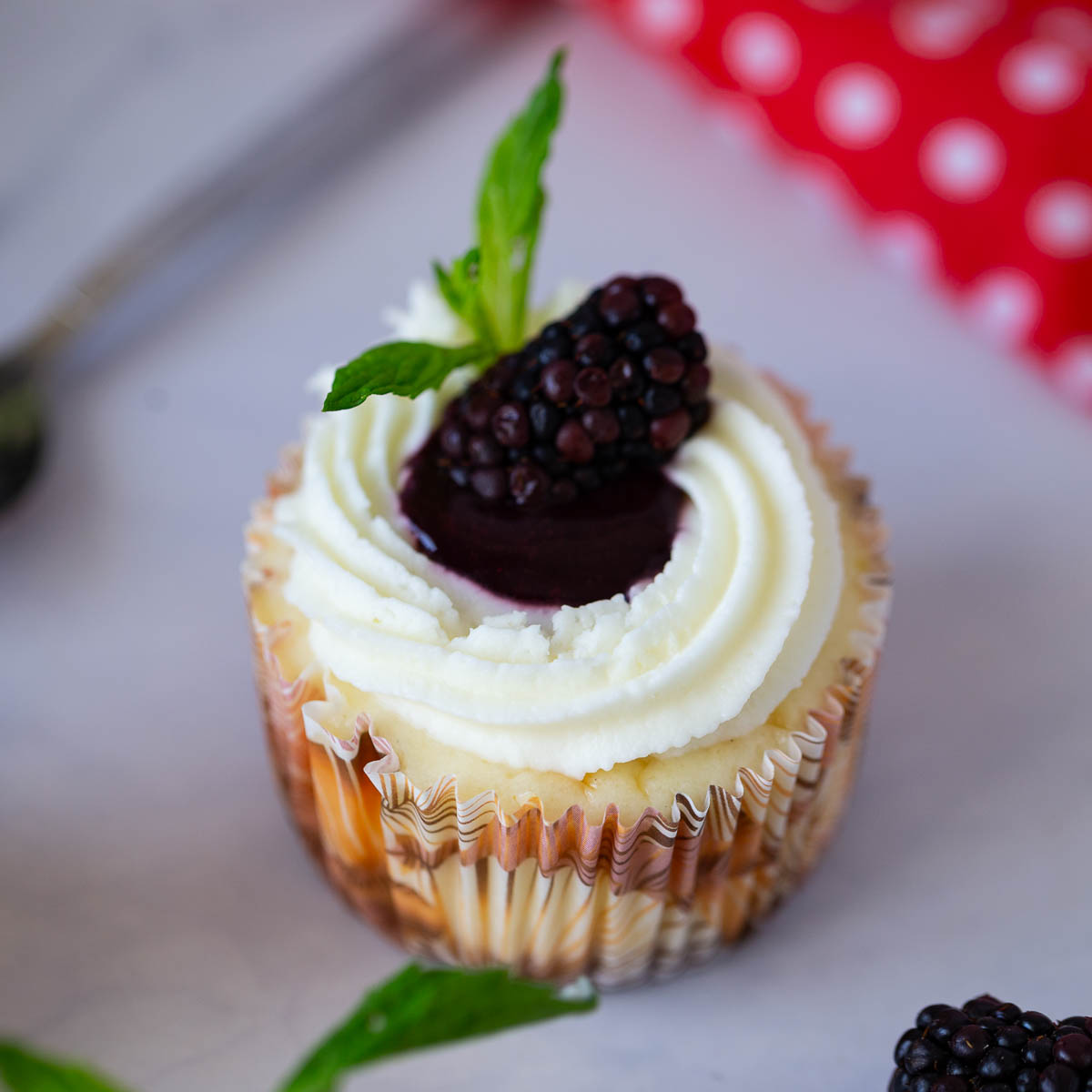 A frosted blackberry cheesecake on the table.