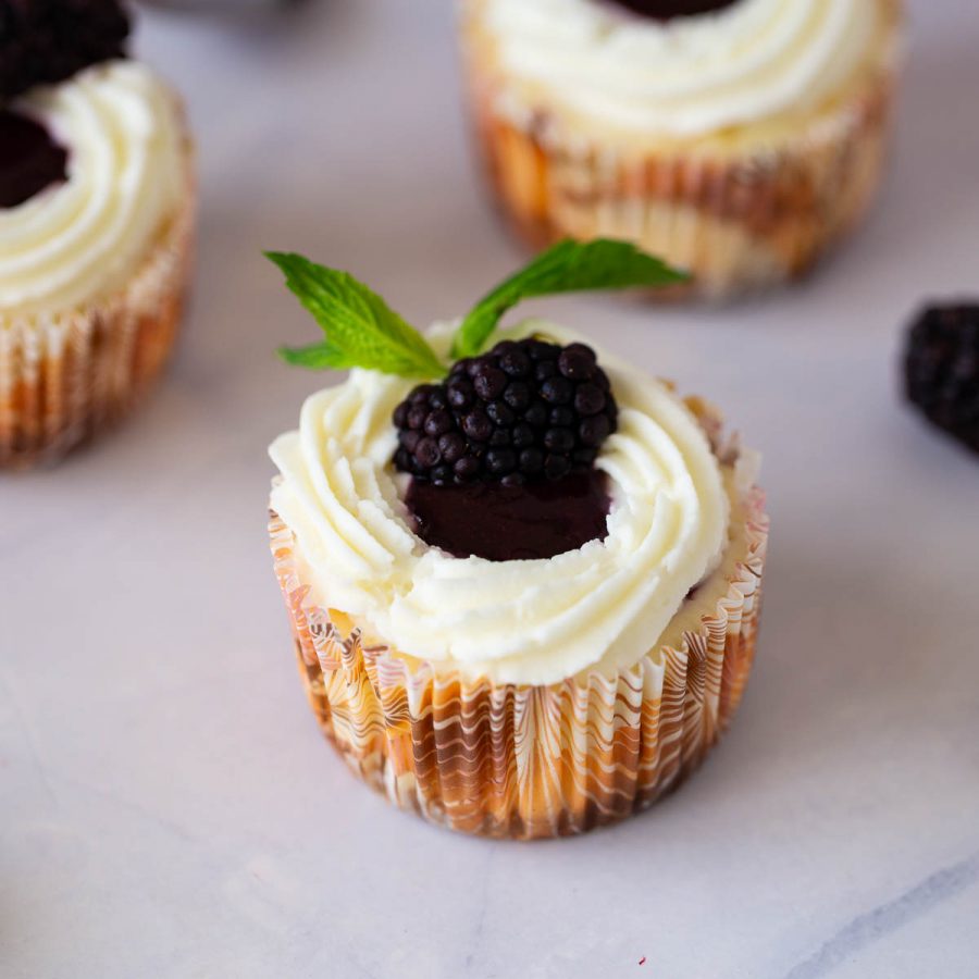A frosted blackberry cheesecakes on the table.