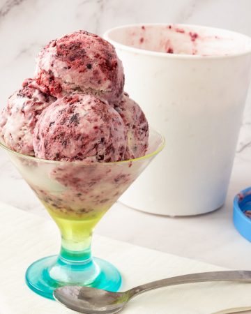 scoops of no churn blackberries ice cream in a bowl.