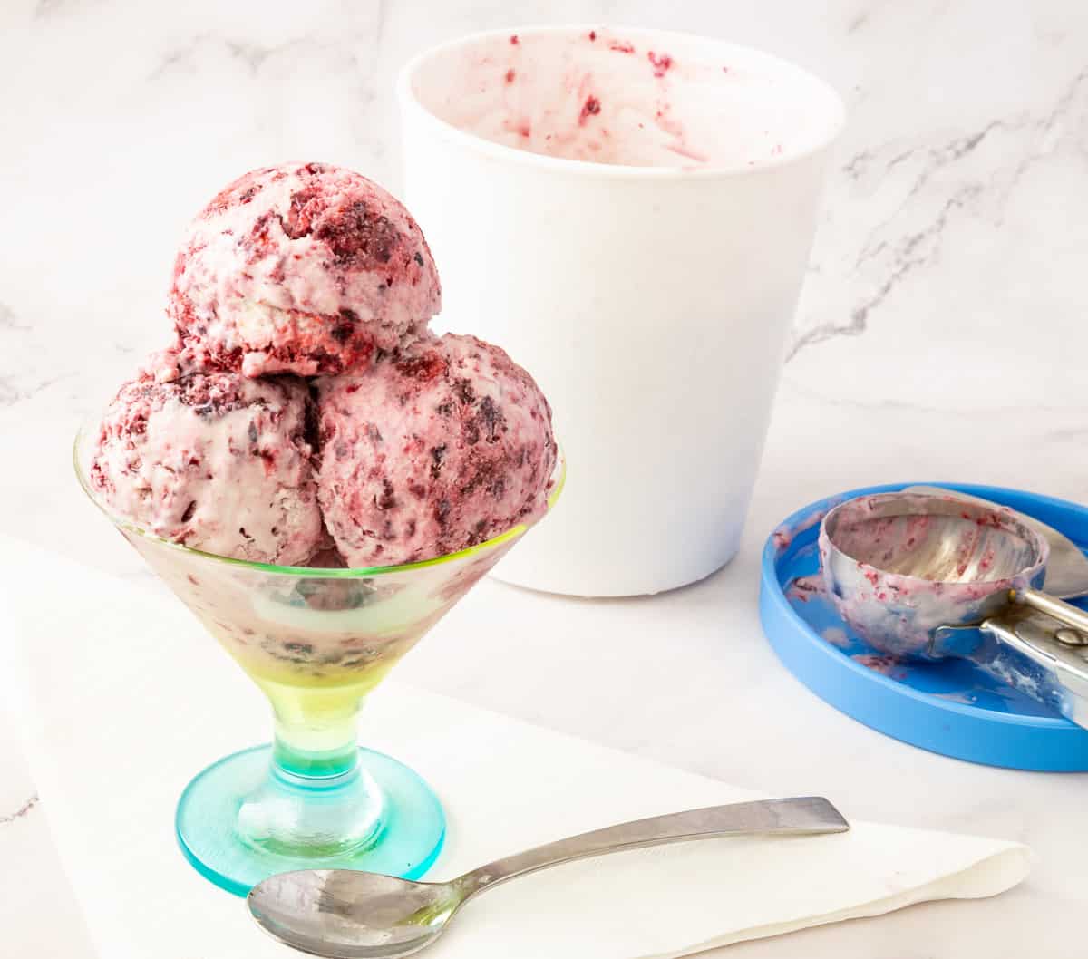 Scoops of no churn blackberry ice cream in a bowl.