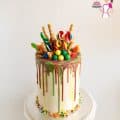 A tall drip cake on a stand.