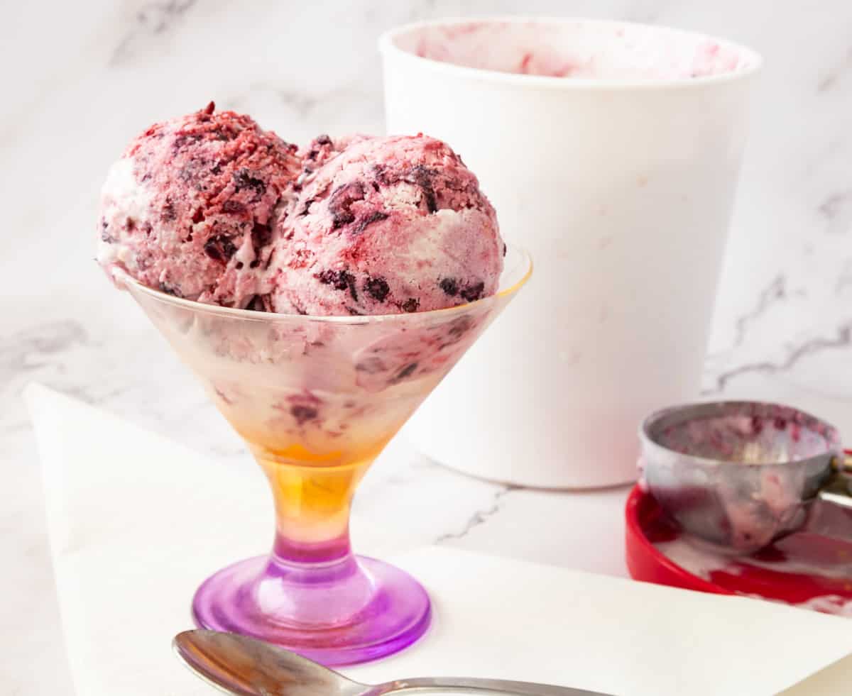 Scoops of mixed berry no churn ice cream in a bowl
