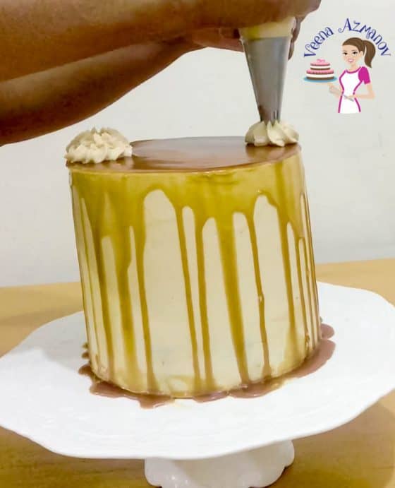 Piping the remaining caramel buttercream on the cake - Progress Pictures