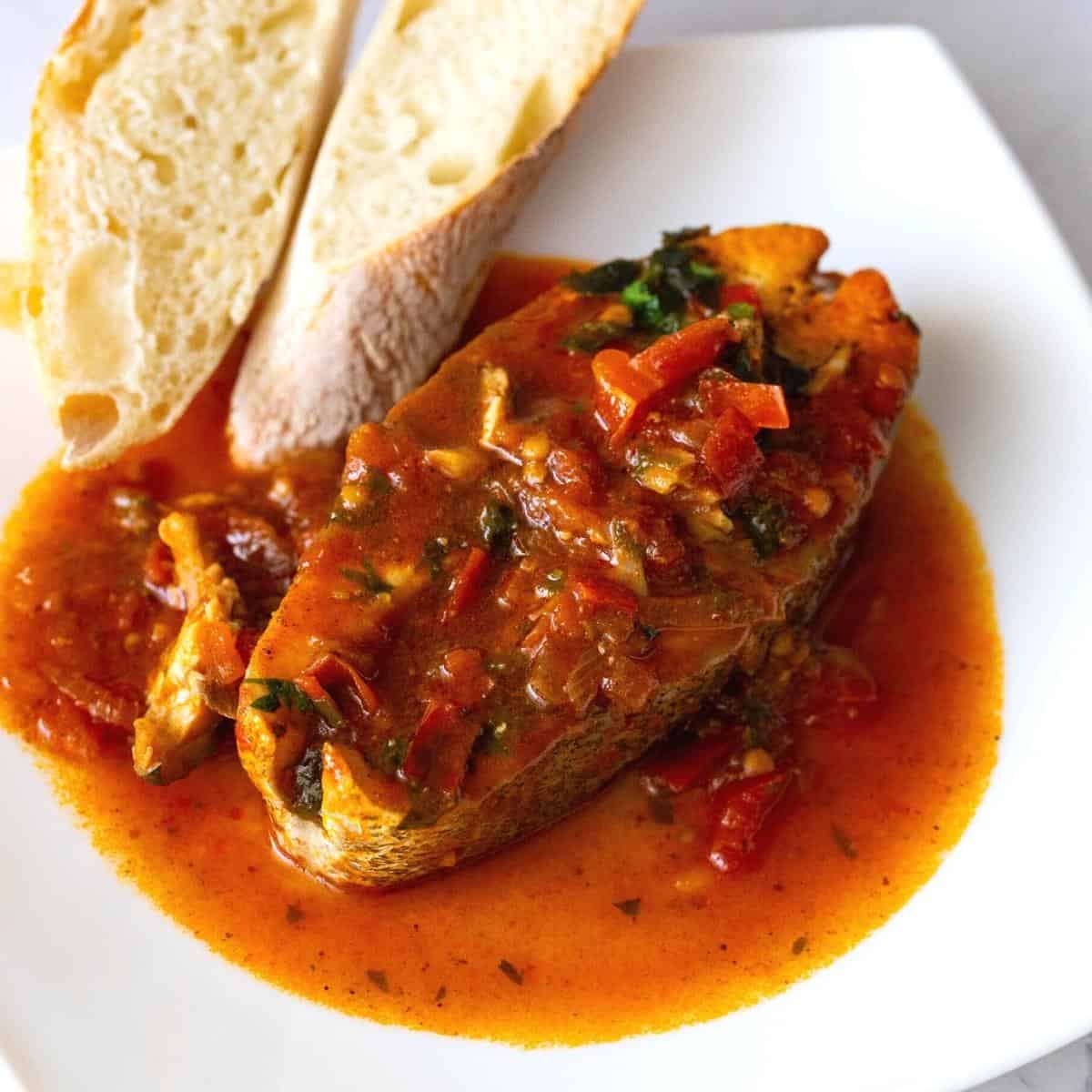 A plate with fish in tomato sauce.