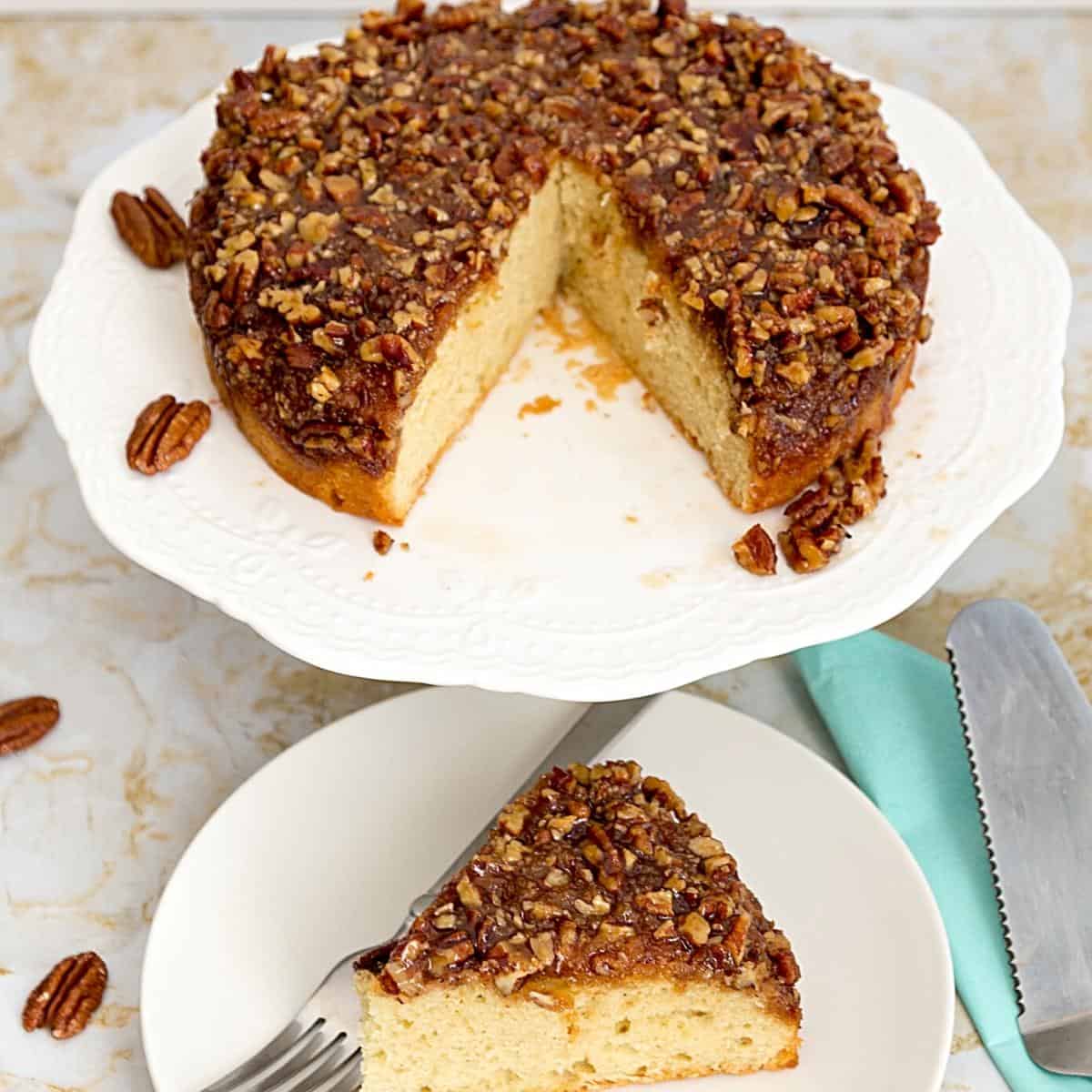 A pecan cake on a cake stand.