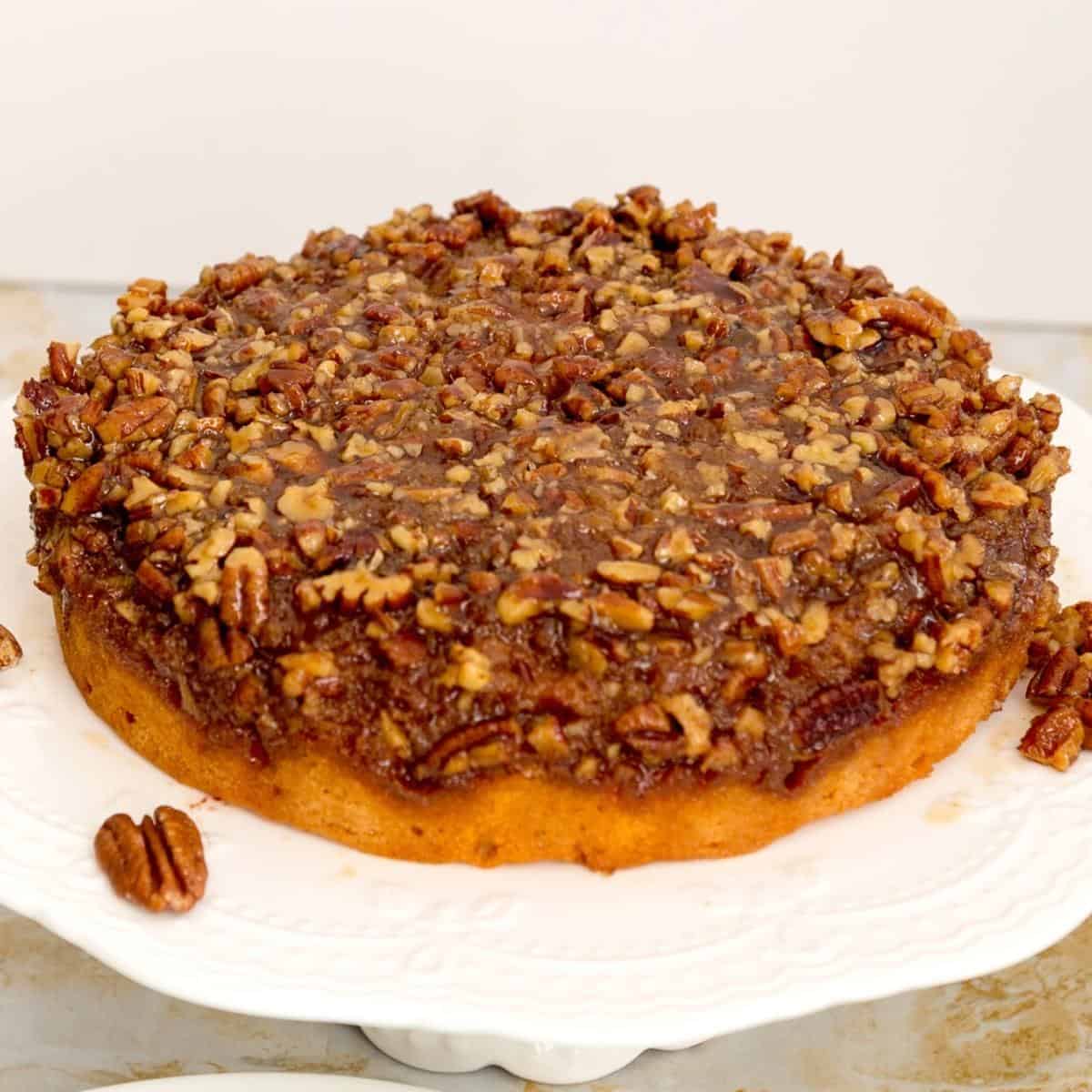 Pecan pie cake inverted on a cake stand.