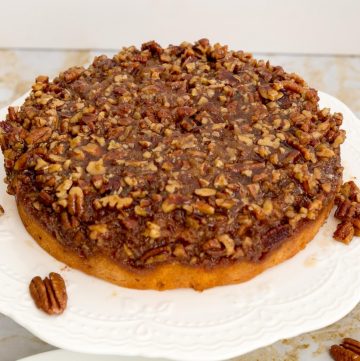 An inverted pecan pie cake on a cake stand.