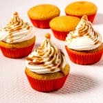 Frosted cupcakes with caramel on the table.