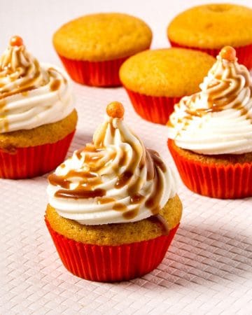 Frosted cupcakes with caramel on the table.