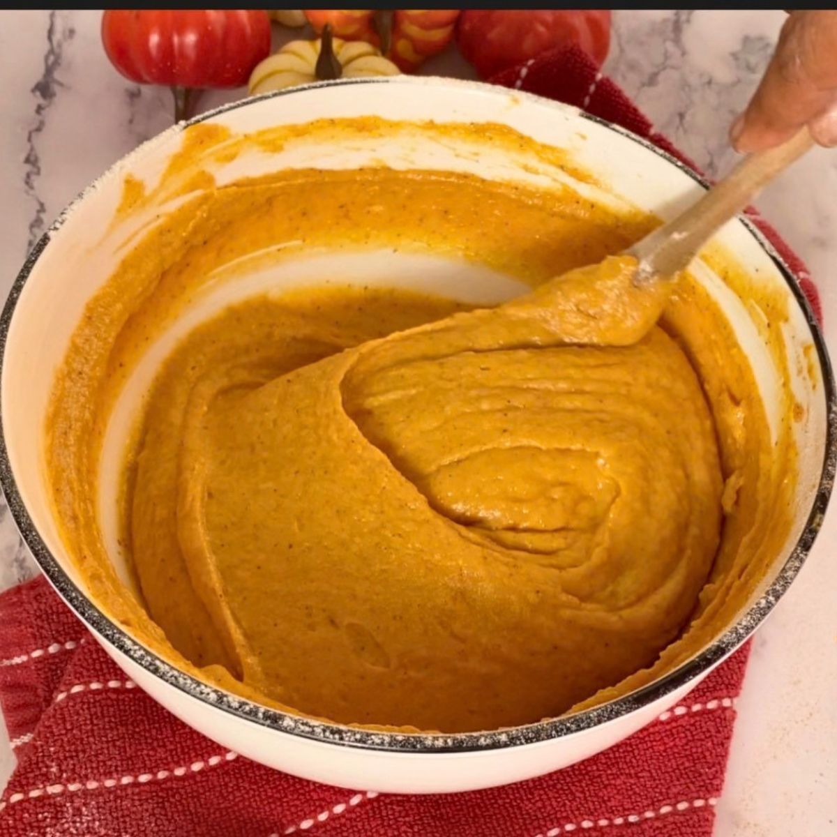 A white bowl with pumpkin cake and cupcake batter.
