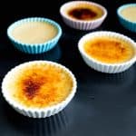 Ramekins with creme brûlée on a table.