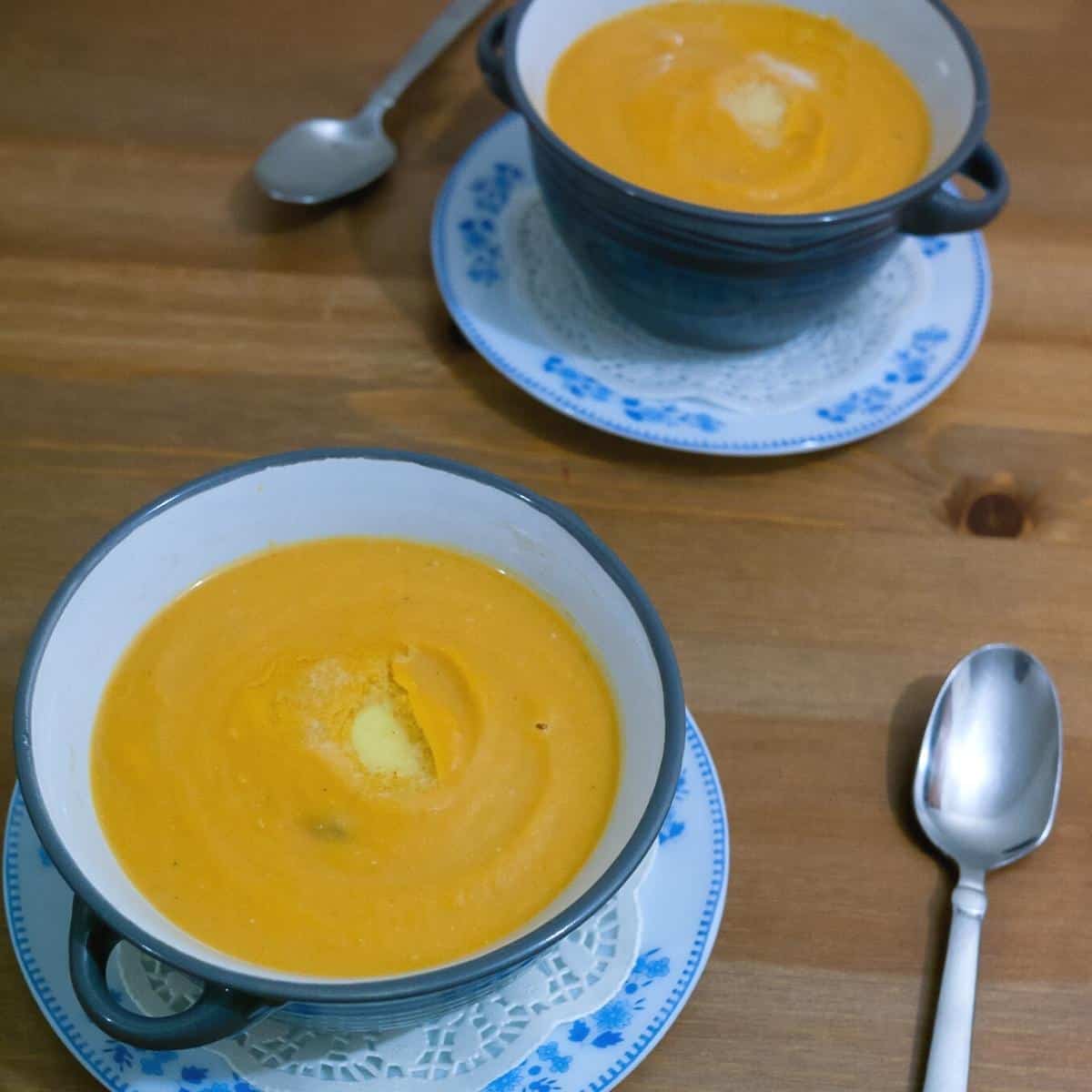 Two bowls with soup made with sweet potato.