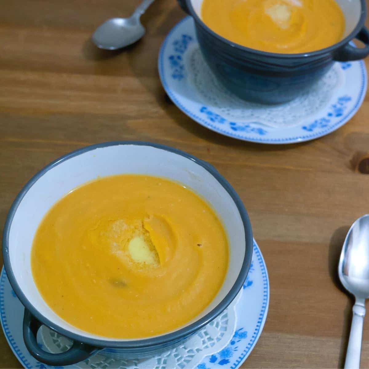 Two soup bowls with sweet potato soup.