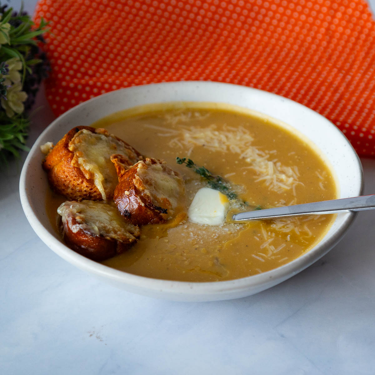 A bowl with sweet potato soup and garlic toast.