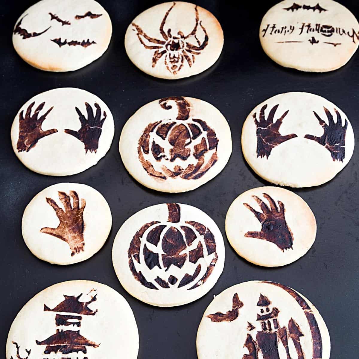 Stenciled cookies on the black board.