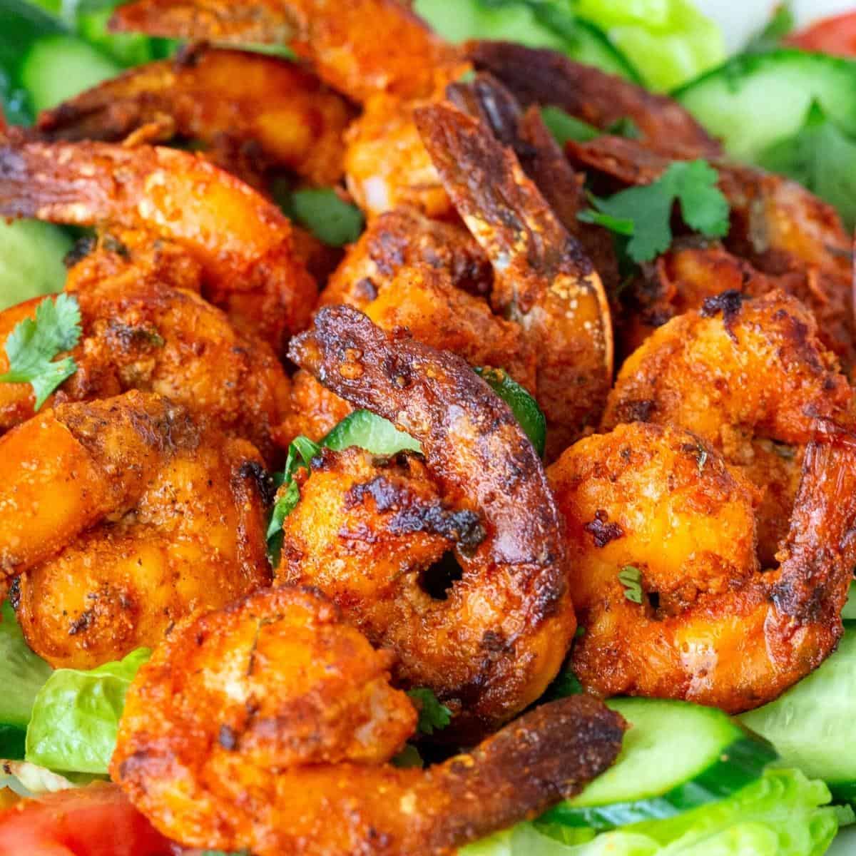 Grilled prawns on a plate of salad.