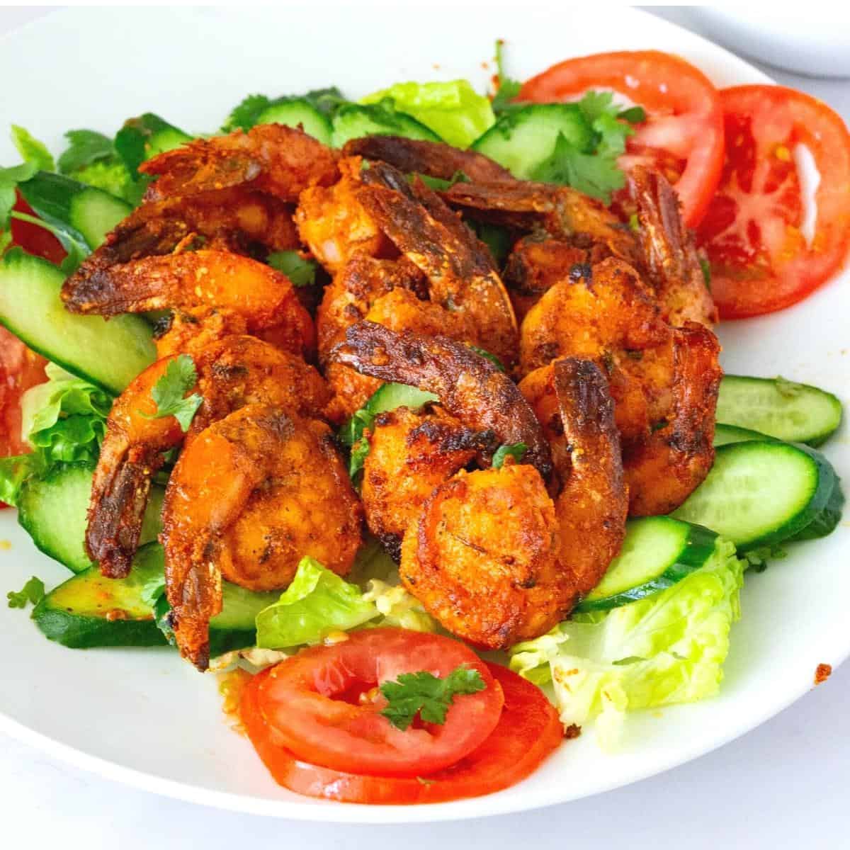A plate with grilled tandoori prawns.