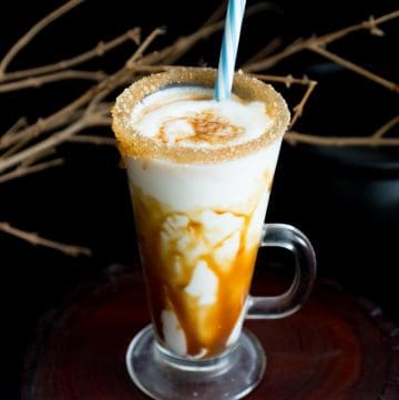 A tall glass with caramel eggnog.