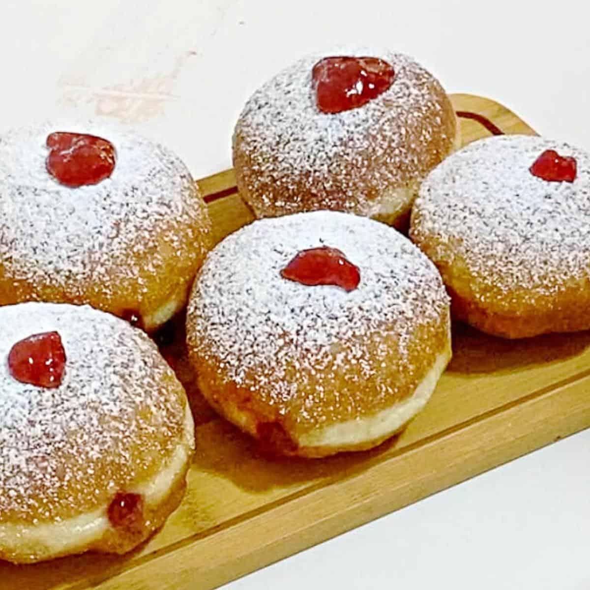 Donuts with jelly on a wooden board.