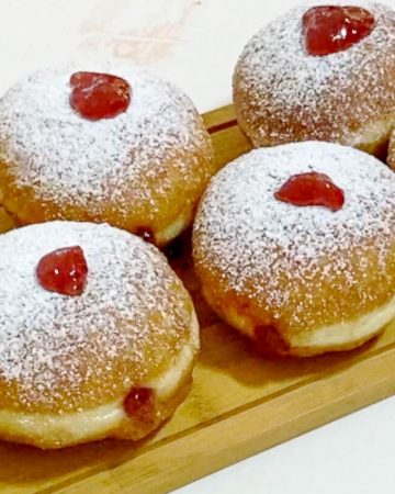 Donuts with jelly on a wooden board.