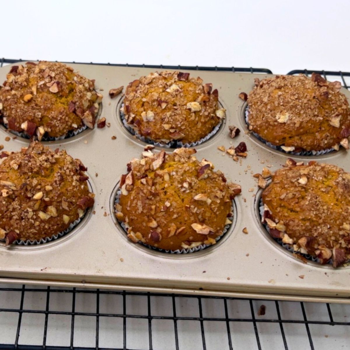 A muffin pan with baked pumpkin muffins.