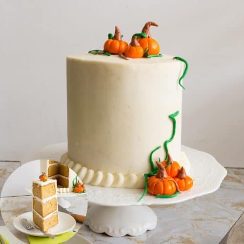 A pumpkin cake with frosting and pumpkin cake toppers.