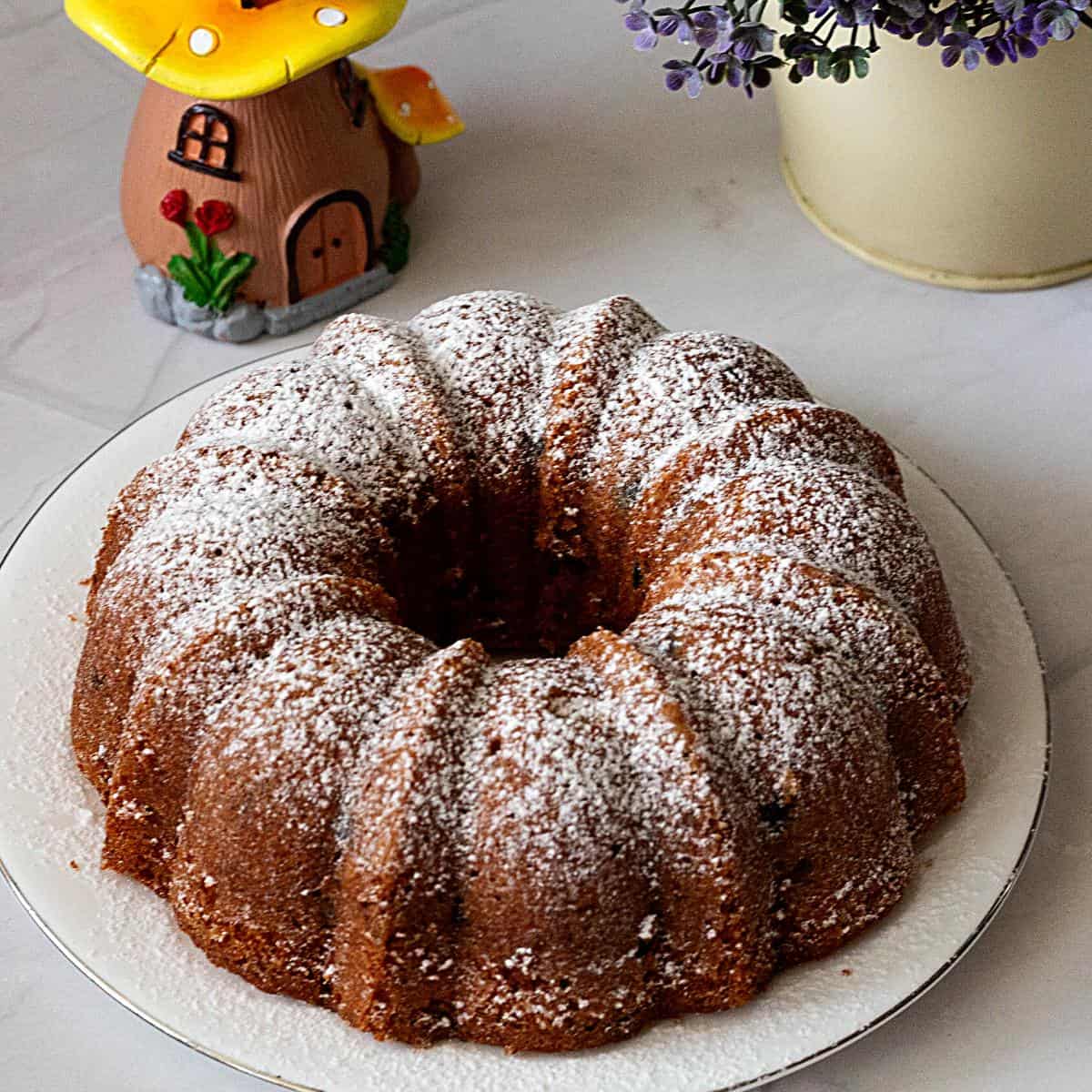 Bundt cake dusted with powdered sugar on the plate.