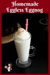A tall glass of eggnog with whipped cream on top.