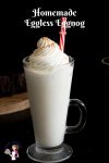 A tall glass of eggnog with whipped cream on top.