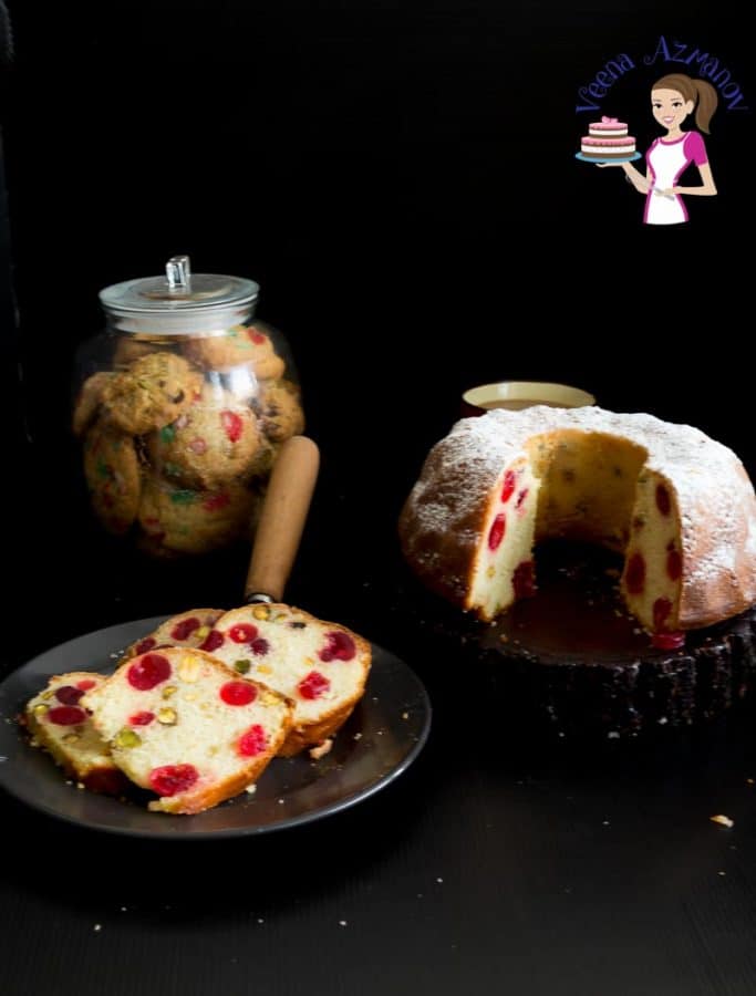 A slice of cherry bundt cake on a plate, next to the remaining cake on a stand.
