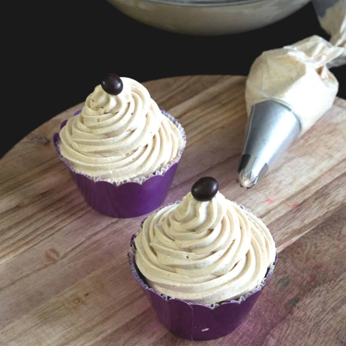 Two cupcakes frosted with coffee buttercream