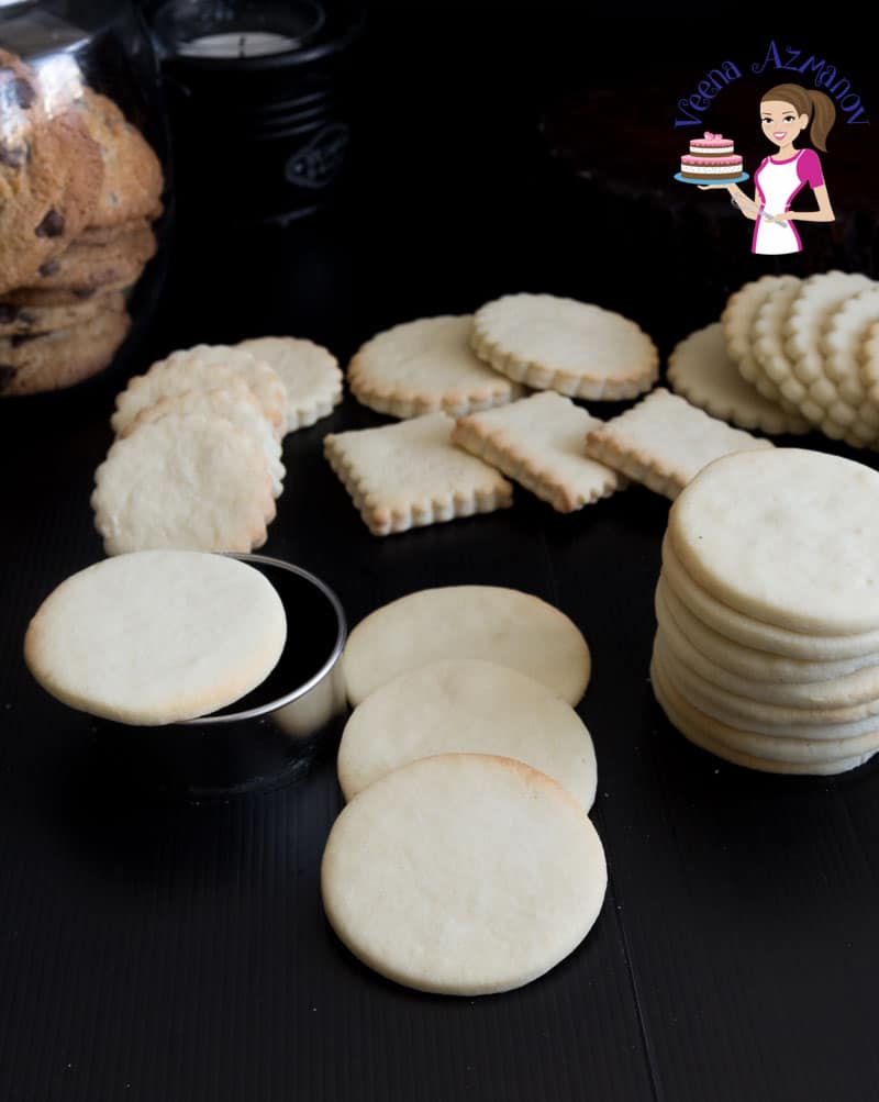 A stack of different shaped vanilla sugar cookies on a table.