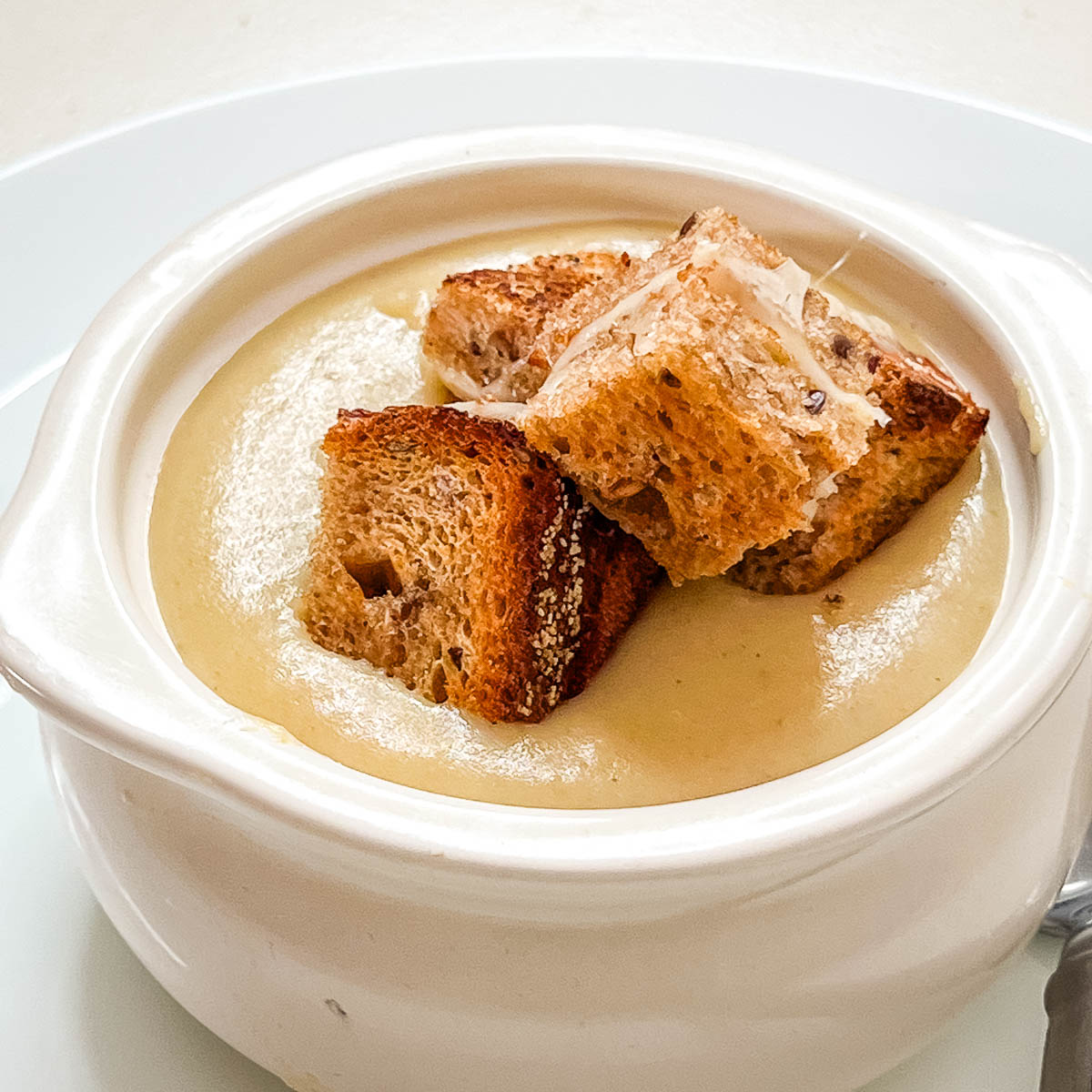 A bowl with potato soup and croutons.