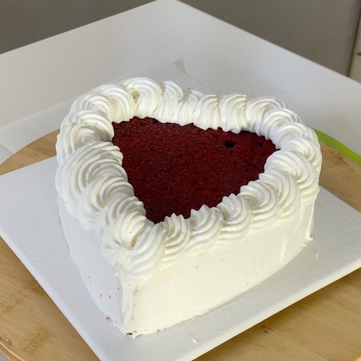 A heart cake frosted with whipped cream.
