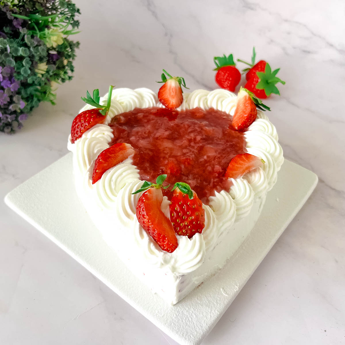 Frosted red velvet heart cake on the cake stand.