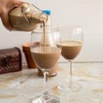 a bottle pouring baileys in a glass