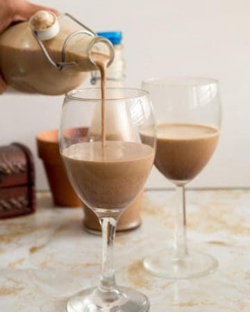 a bottle pouring baileys in a glass