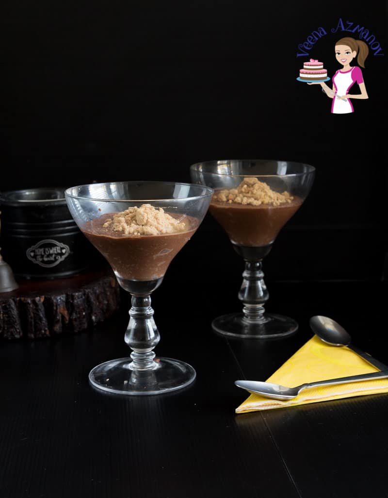 Two glasses of chocolate mousse on a table.