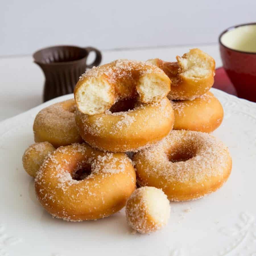 A stack of sugar donuts on a table.