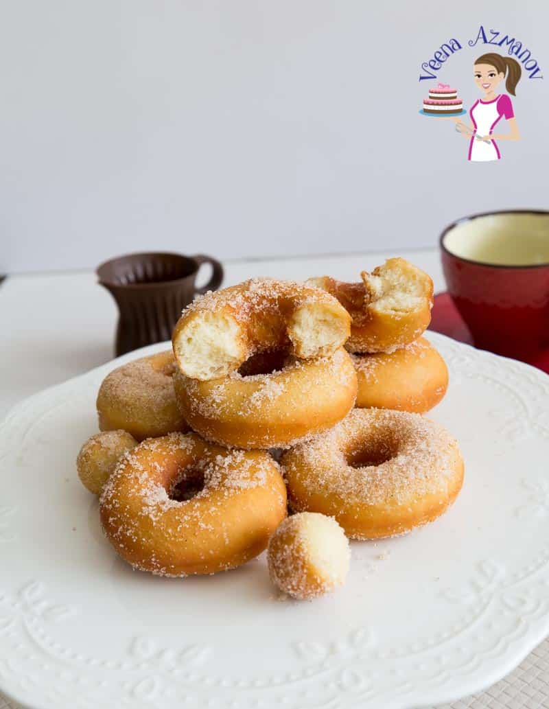 A stack of sugar donuts on a table.