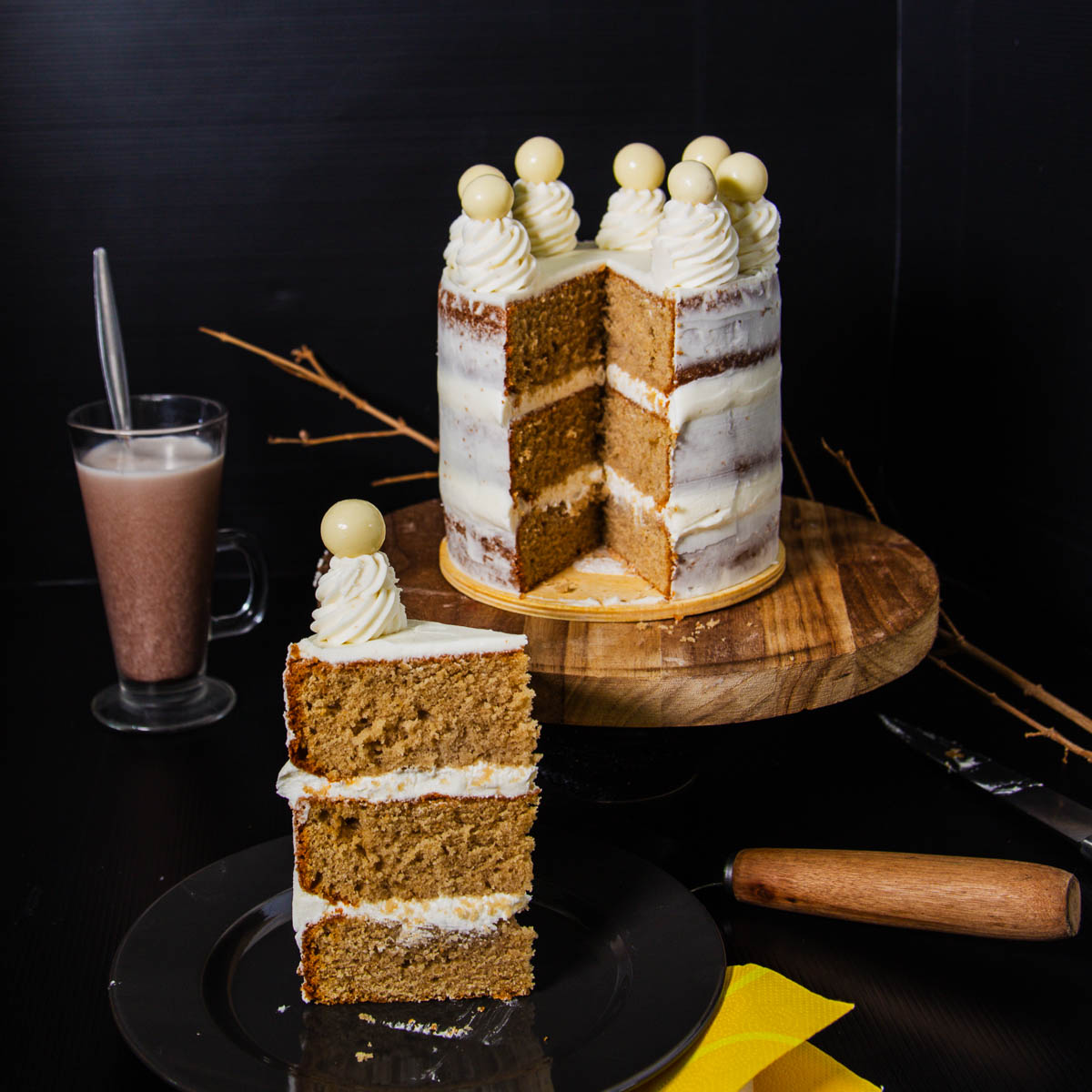 A sliced frosted cake on the table.